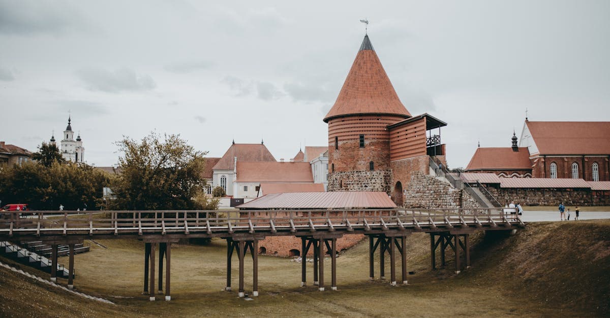 Historic Kaunas Castle's red brick towers and wooden bridge, marking Lithuania's central European geography