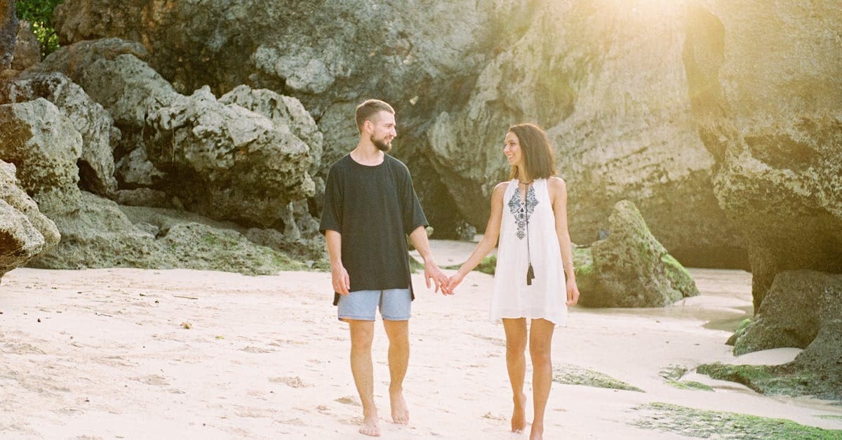 Happy couple strolling barefoot on a Bali beach, answering is Bali safe for Australian tourists visiting