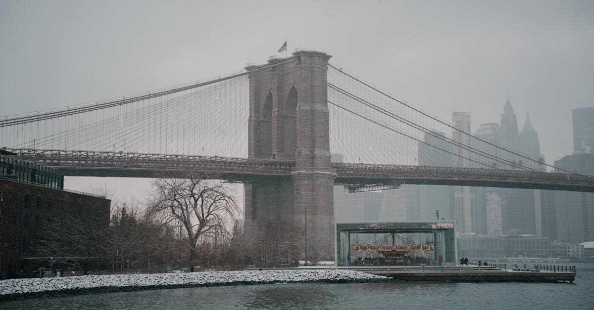 Brooklyn Bridge draped in fresh snow during a serene New York City winter snowfall.