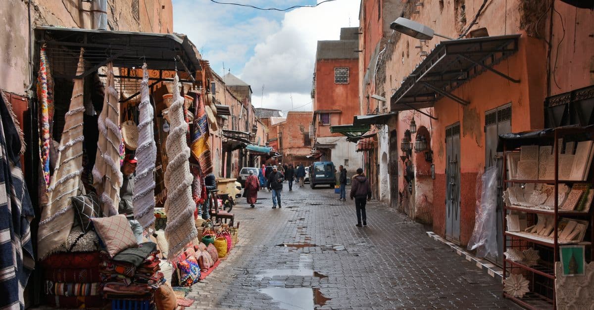 Mercado de Marrakech con telas vibrantes y arquitectura tradicional que refleja el tiempo en Marrakech mes a mes