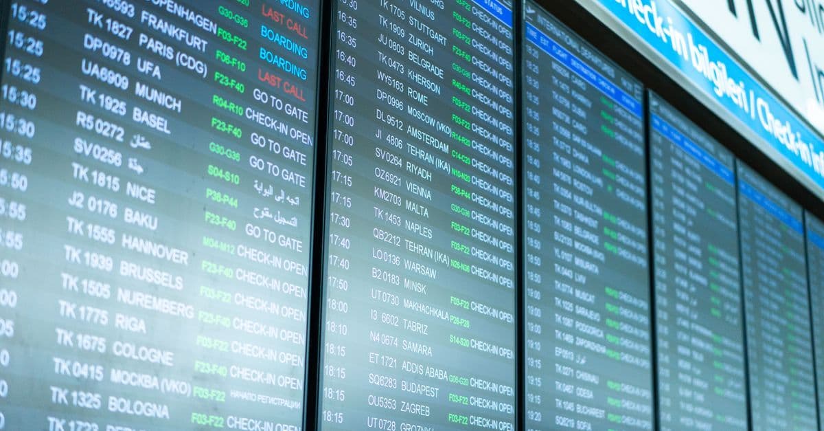 Airport terminal departure boards displaying gate details and schedules to help travellers manage flight connections.
