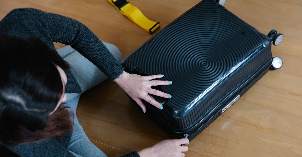 Woman deciding between hard shell and soft shell carry on suitcase options while packing at home
