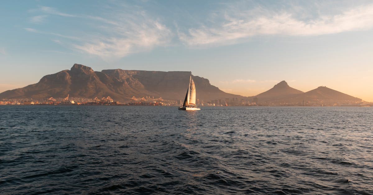 Sailboat near Table Mountain at sunset, ideal backdrop for comparing the best travel insurance south africa