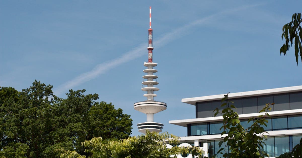 View of the iconic Heinrich Hertz Tower among trees in Hamburg, Germany, on a sunny day.