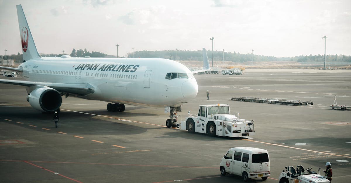 Japan Airlines aircraft on Tokyo tarmac with ground crew vehicles, a top carrier for the toronto to tokyo flight![image