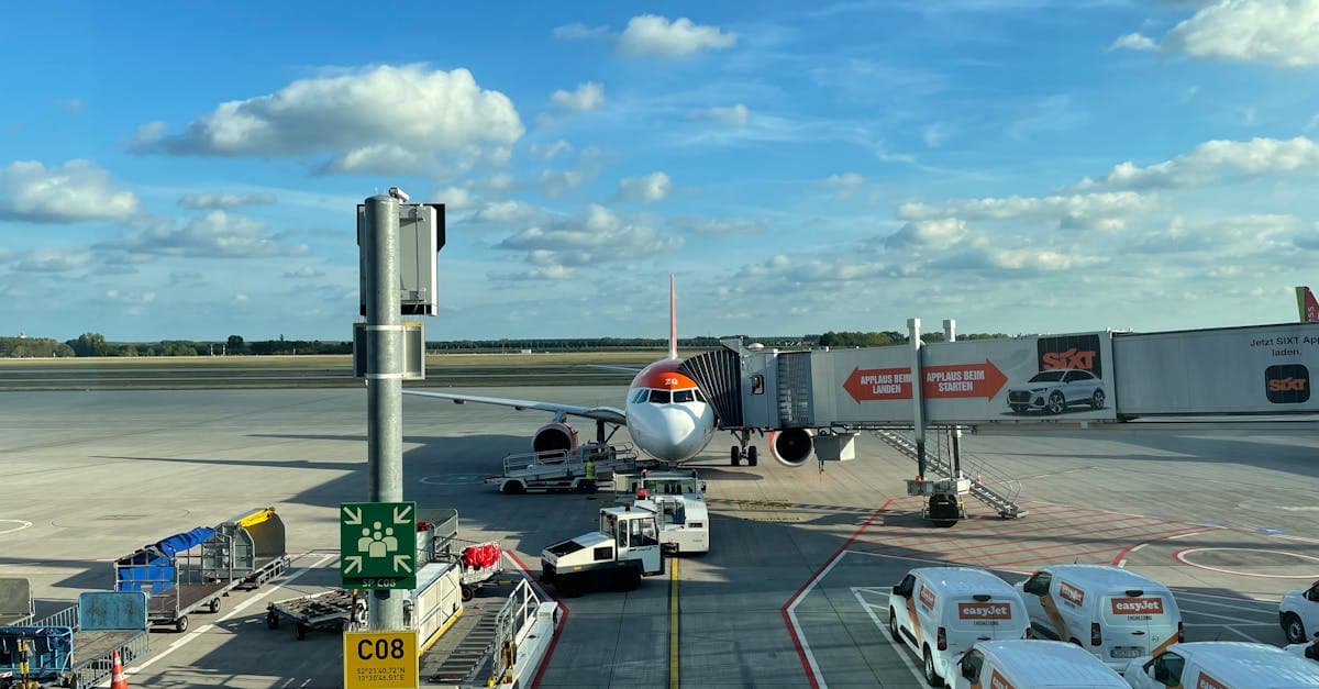 Vliegtuig aan de gate op een druk Düsseldorf Airport met grondpersoneel en voertuigen rondom.