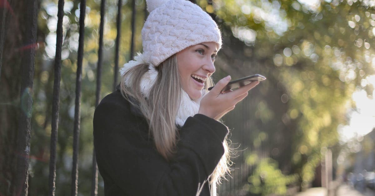 Smiling young woman using a smartphone outdoors in winter clothing, contacting SMARTY customer support