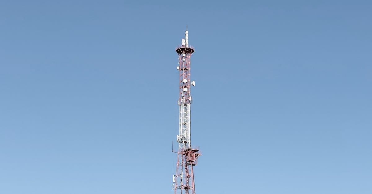 Korkea tietoliikennetorni kirkkaan sinistä taivasta vasten kuvastaa suomalaisten telecom-yhtiöiden osakevertailua sijoittajille