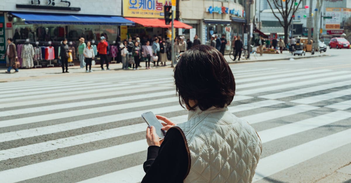 Kobieta sprawdza telefon na zatłoczonej ulicy w Korei — najlepsza karta eSIM dla Polaków podróżujących do Japonii i Azji