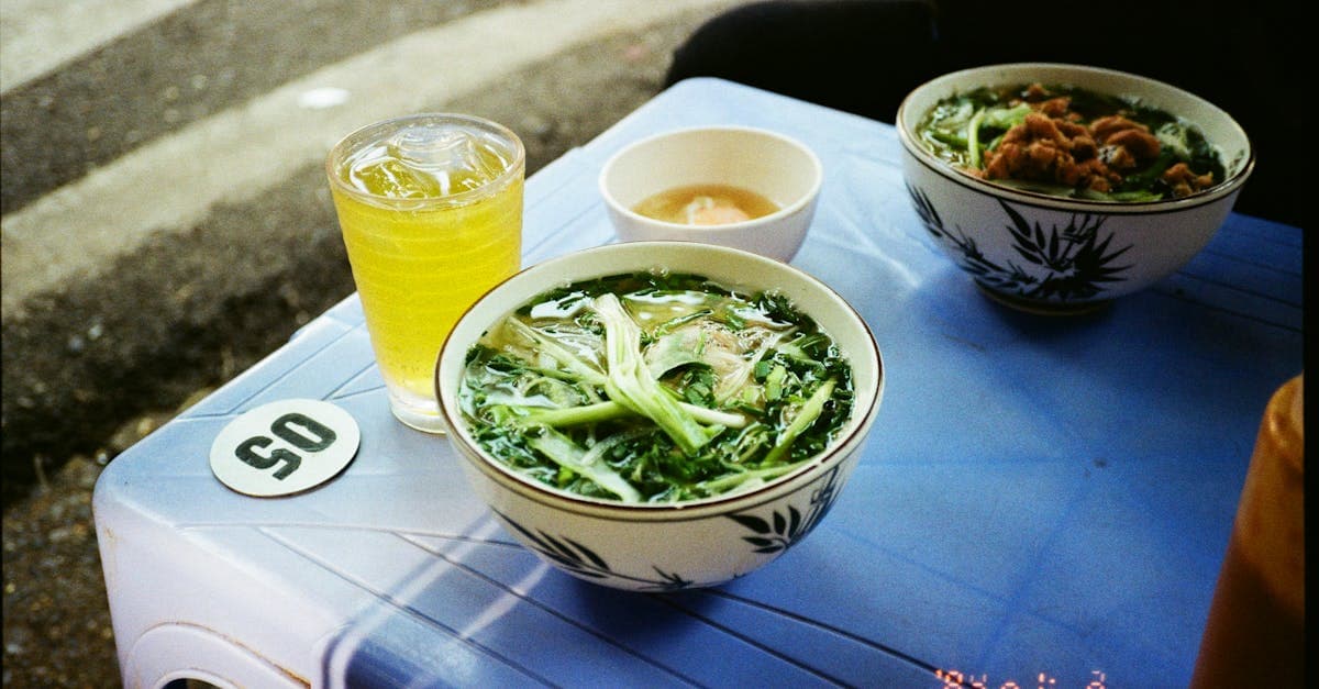 Street food in Hanoi showcasing traditional Vietnamese pho and iced green tea at a pavement stall.