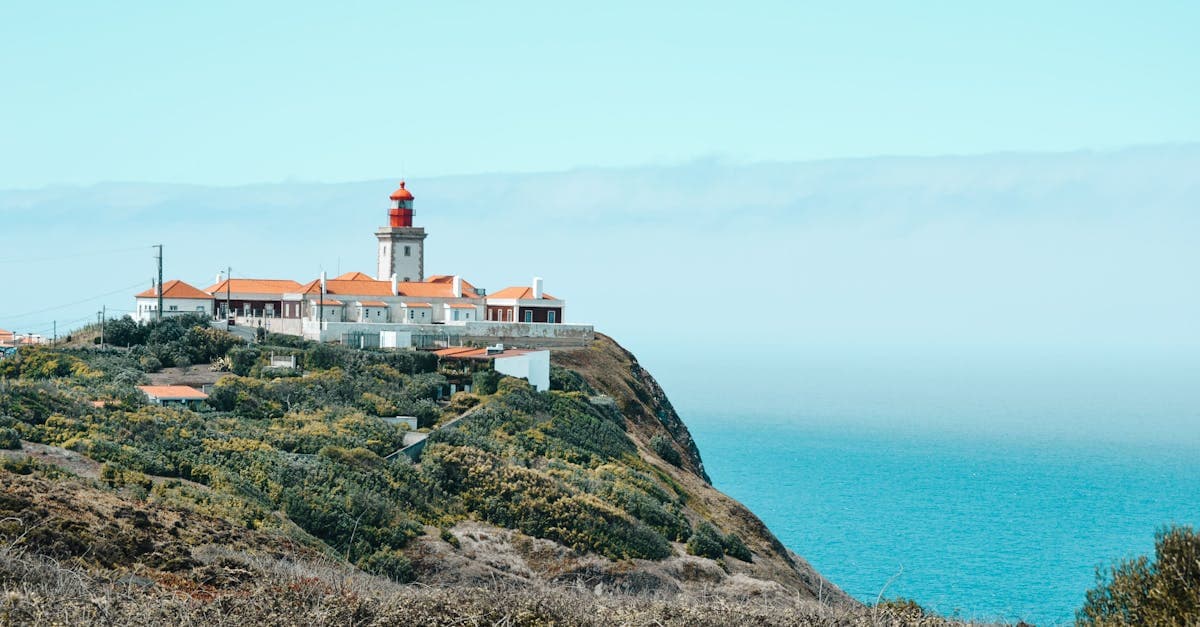 Faro portoghese su una scogliera a picco sull'oceano, simbolo di indipendenza per chi ama viaggiare da soli.