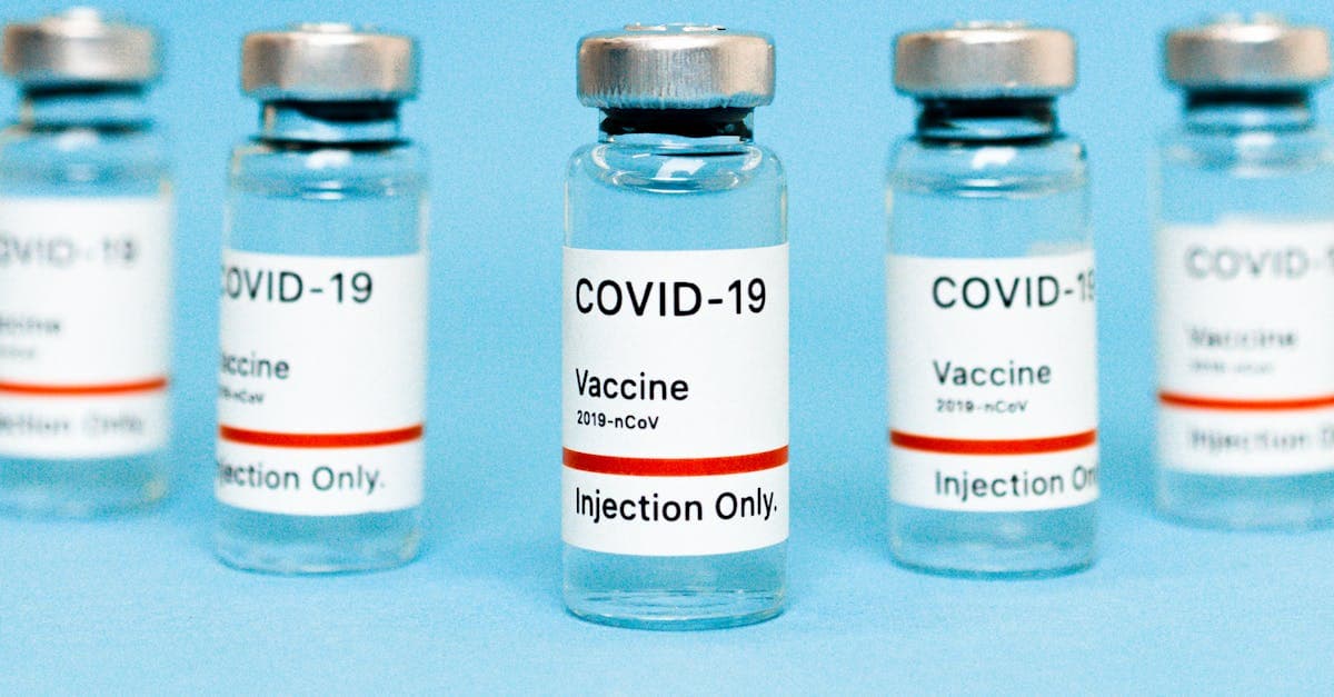 Flacons de vaccins sur fond bleu illustrant les coûts de vaccination et les remboursements RAMQ ou assurance collective.