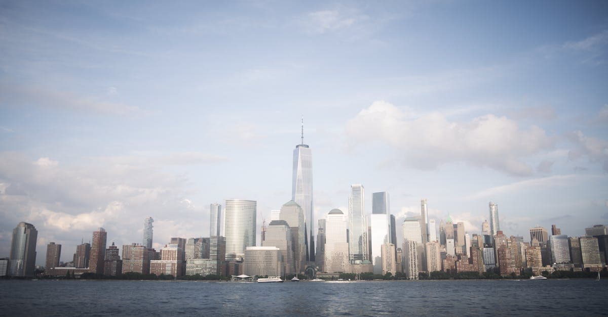 Stunning view of New York City's skyline featuring the iconic One World Trade Center under a blue sky.