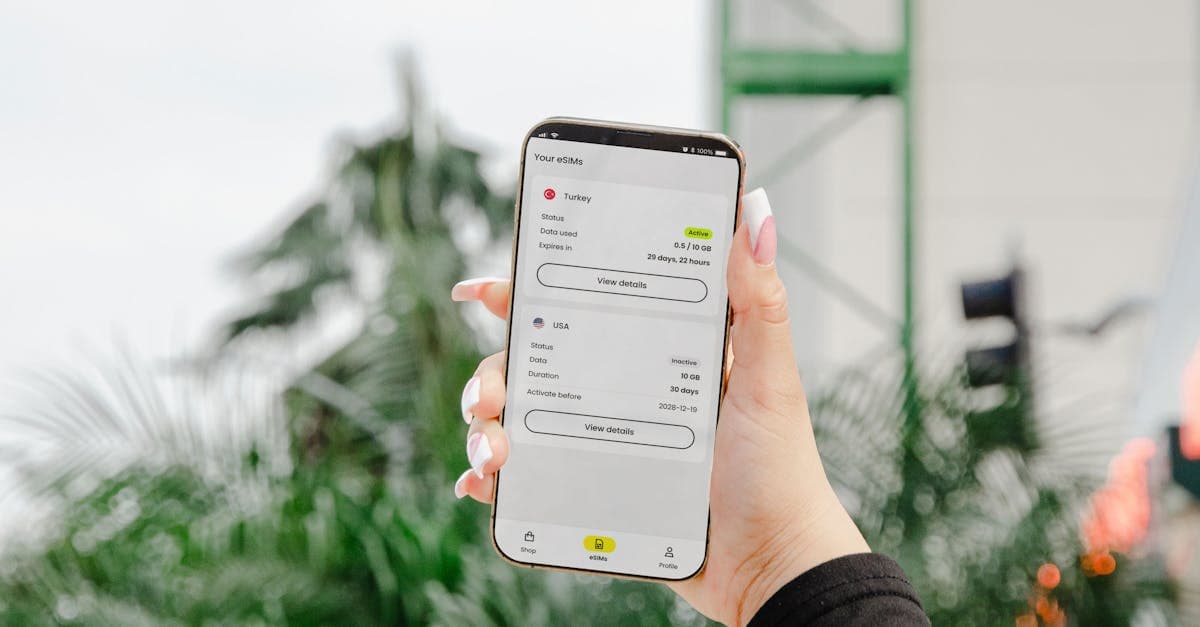 Close-up of a woman's hand holding a smartphone with an eSIM app displaying data plans, set against a blurred outdoor background.