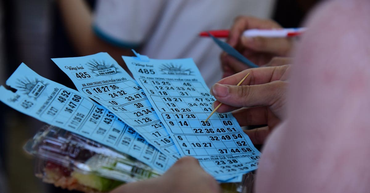 Nhóm người cầm thẻ bingo xanh và bút trong nhà, minh họa câu hỏi thường gặp về xổ số