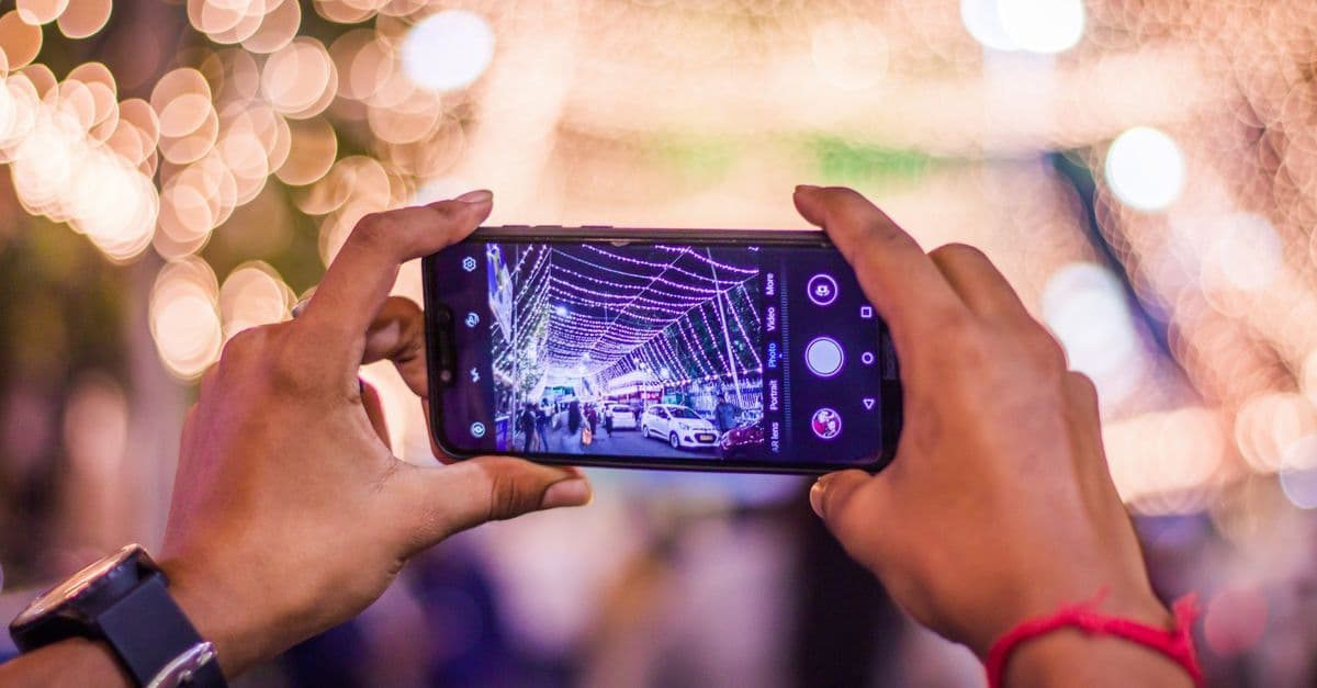 Mains tenant un smartphone pour rester connecté en Thaïlande par tous les temps grâce à une eSIM de voyage.