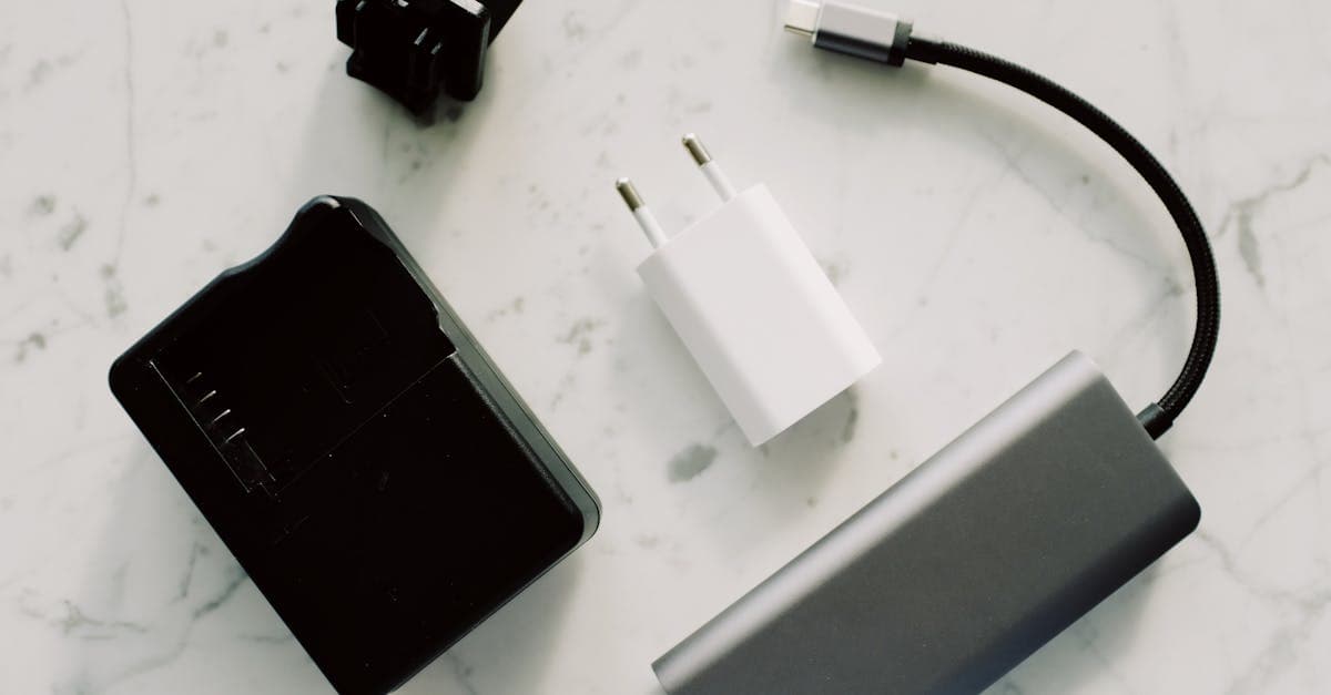 Collection of travel adapters and cables on marble, showing essential electronics for Singapore's plug type