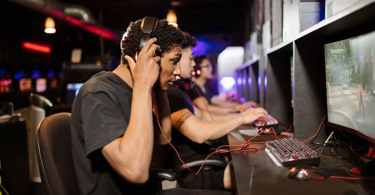 Young adults gaming together at an internet cafe in a modern, vibrant lounge setting