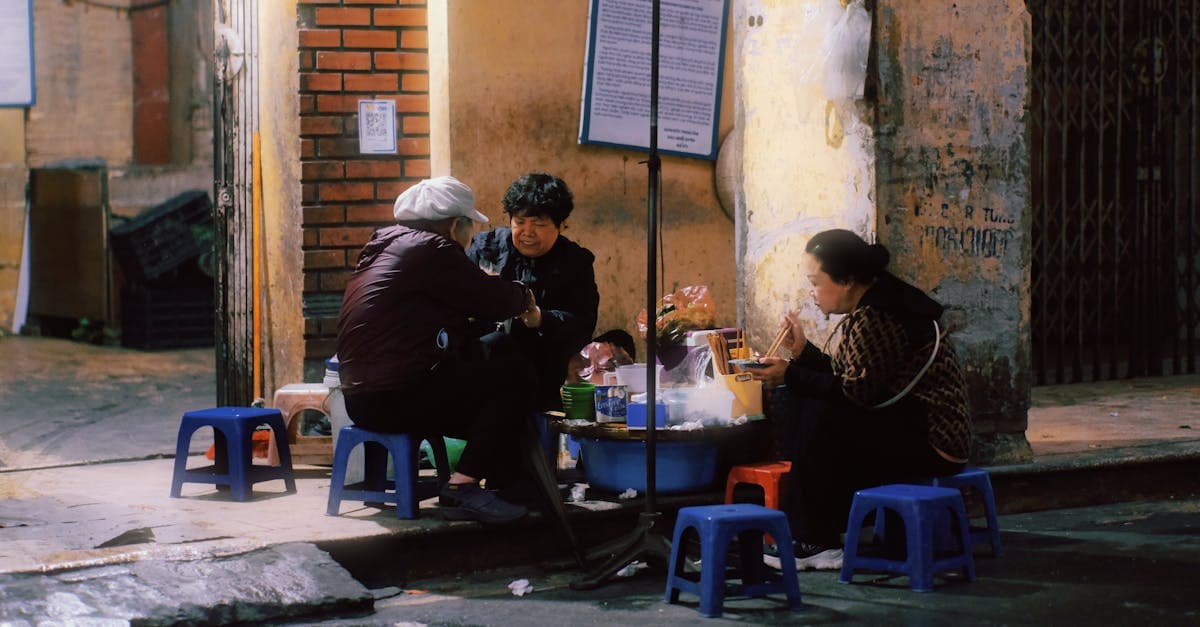 Locals gather to enjoy street food in Hanoi's vibrant night market under warm evening lights.