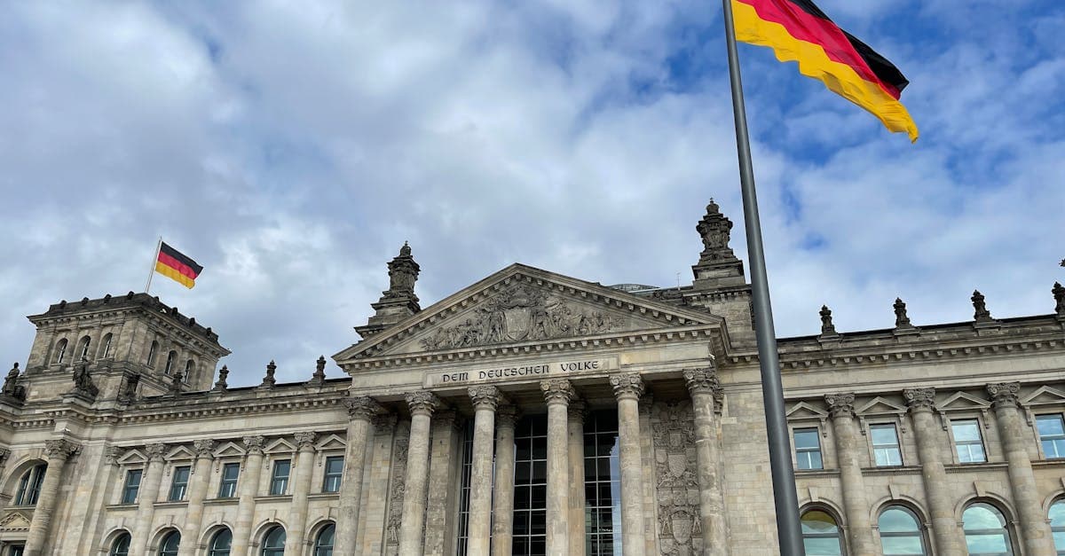 Reichstagsgebäude mit Deutschlandfahne vor blauem Himmel – beste Länder für Deutsche, die im Ausland arbeiten wollen
