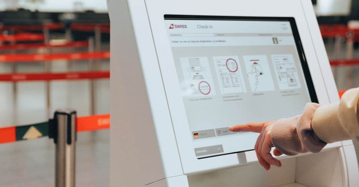 Reisender bedient einen Self-Check-in-Automaten im Abflugterminal des SZG für einen reibungslosen Reisestart.
