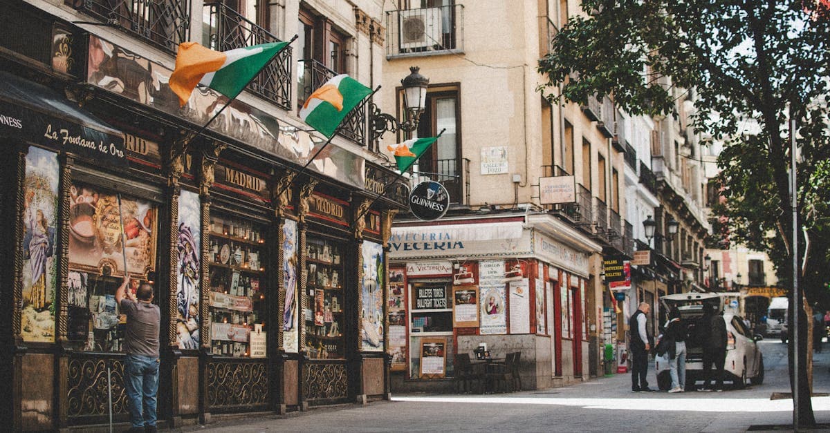 Calle bulliciosa del centro de Madrid con tiendas locales, mostrando la vida urbana de una capital europea asequible