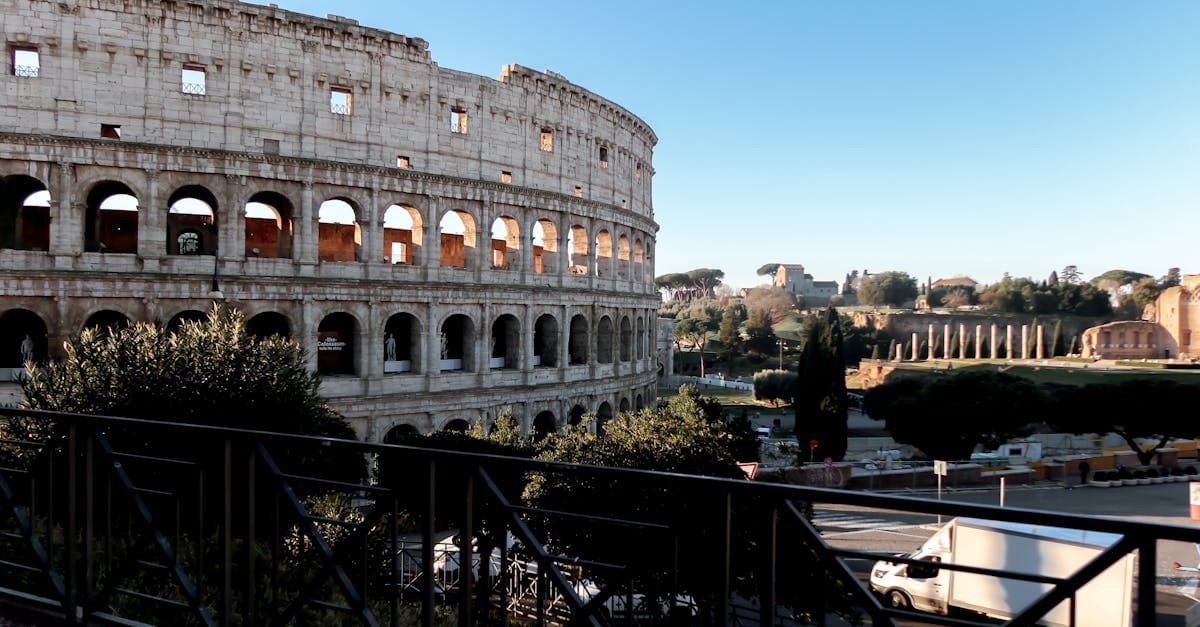 The Colosseum's dramatic arched facade rising against a clear sky, helping you plan your Rome itinerary