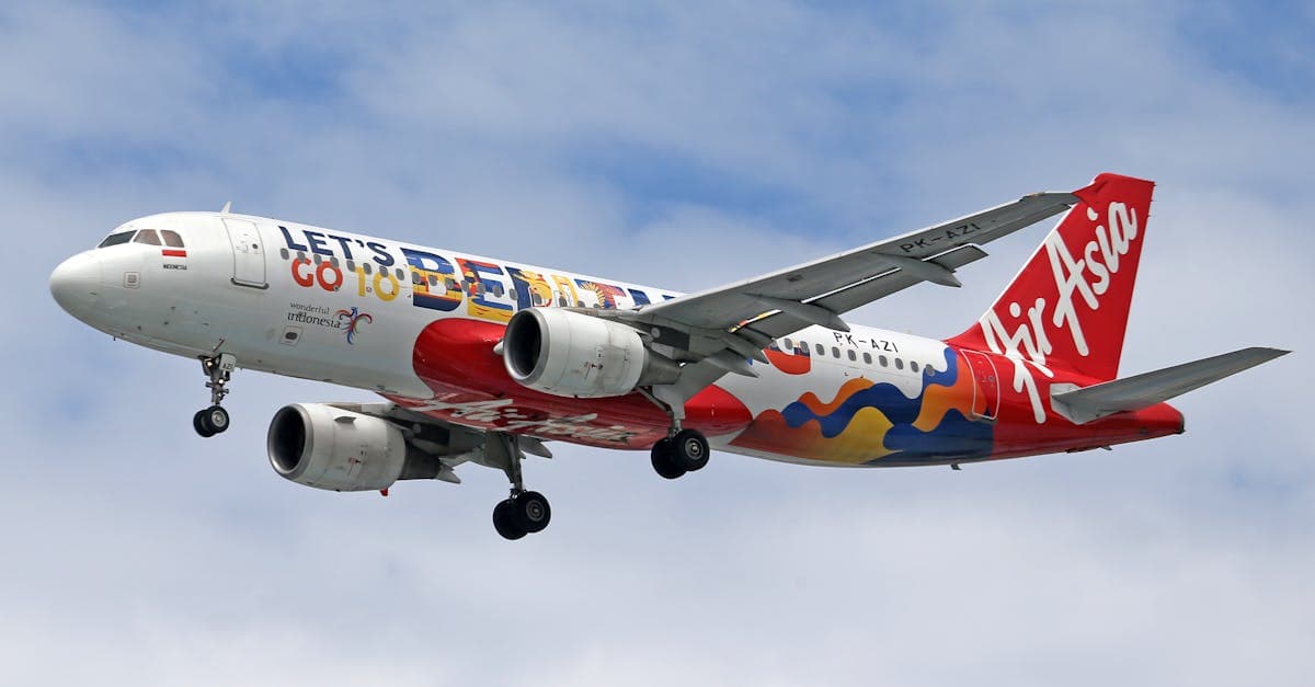 AirAsia aircraft flying through the sky with vibrant livery promoting Bali travel.