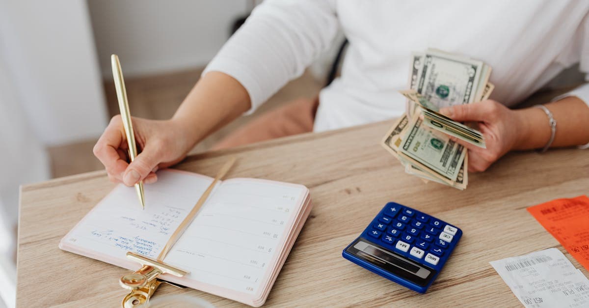 Person budgeting at home, calculating the monthly cost of portable wifi for travel with cash and a calculator