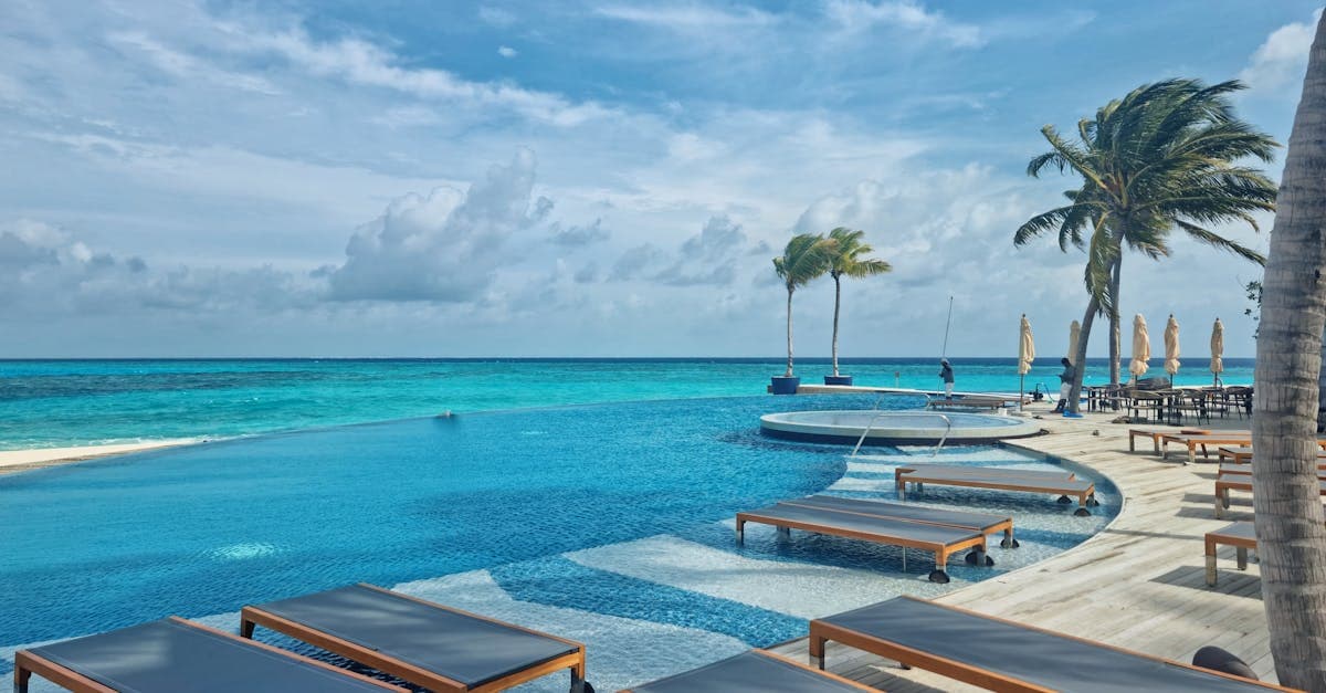 Piscina infinity di un resort di lusso alle Maldive con palme tropicali durante la stagione umida