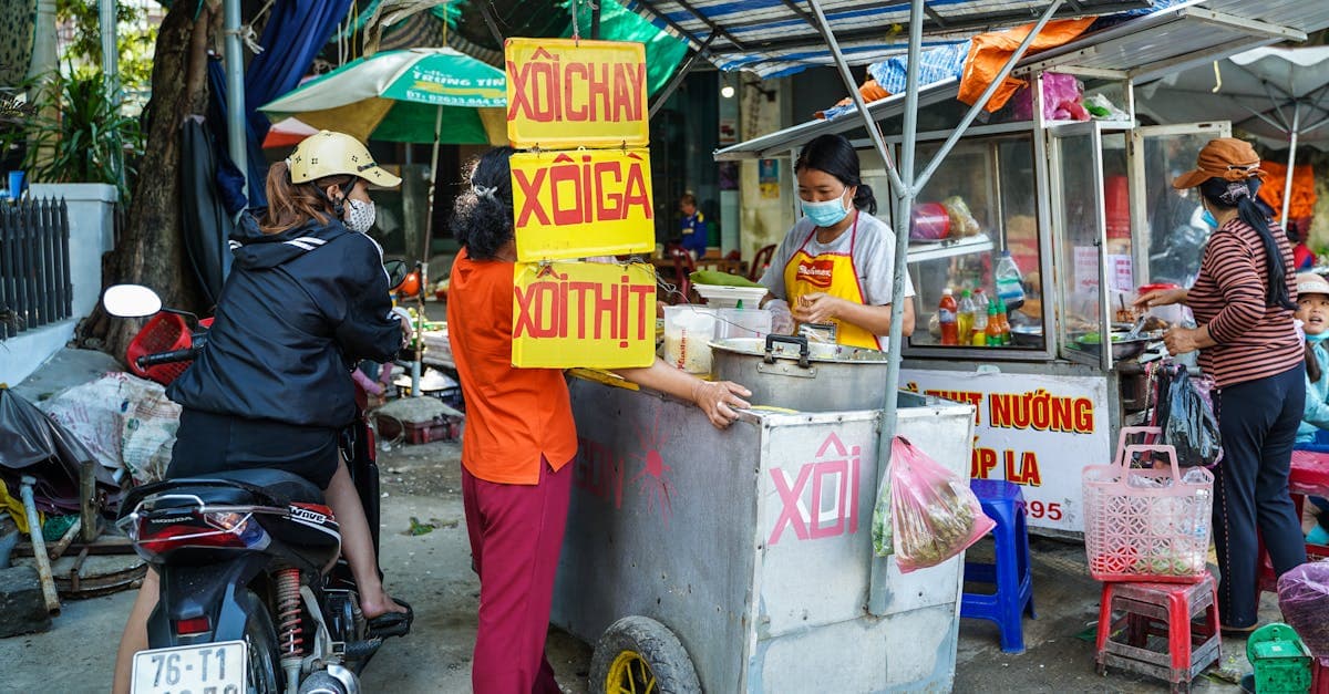 A vendor serving underrated xoi sticky rice and banh tom at a Hanoi street food market.
