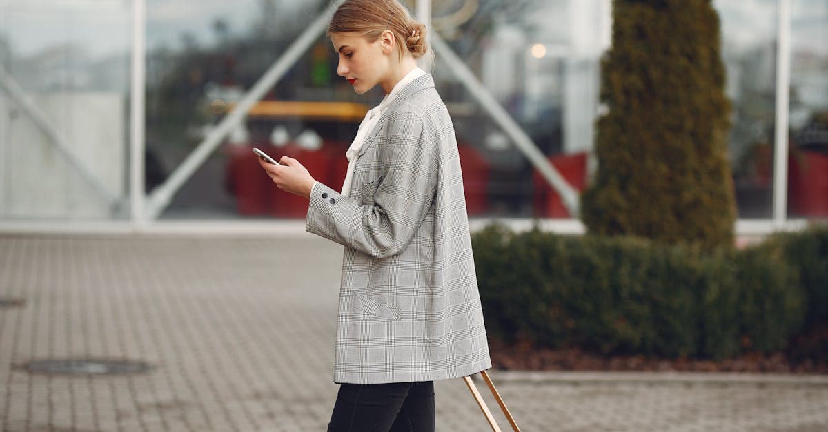 Traveller with suitcase using smartphone near airport terminal after renting portable wifi on arrival