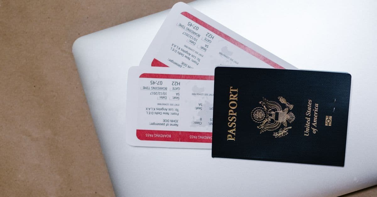 A United States passport rests on two boarding passes atop a white sheet of paper.