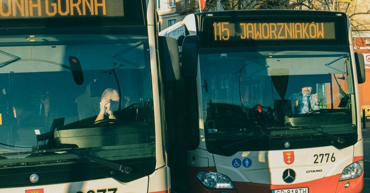Autobusy publiczne na przystanku – porównanie kosztów dojazdu na lotnisko przy tanich lotach z Warszawy