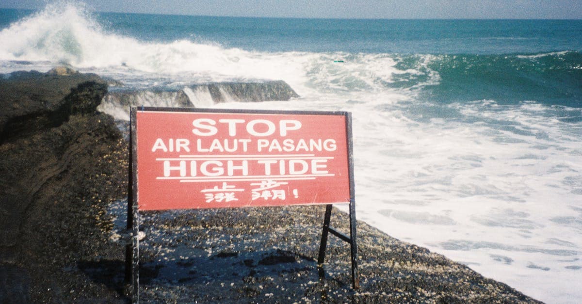 Warning sign at a rocky Bali seashore, understanding food, water and health risks when asking is Bali safe