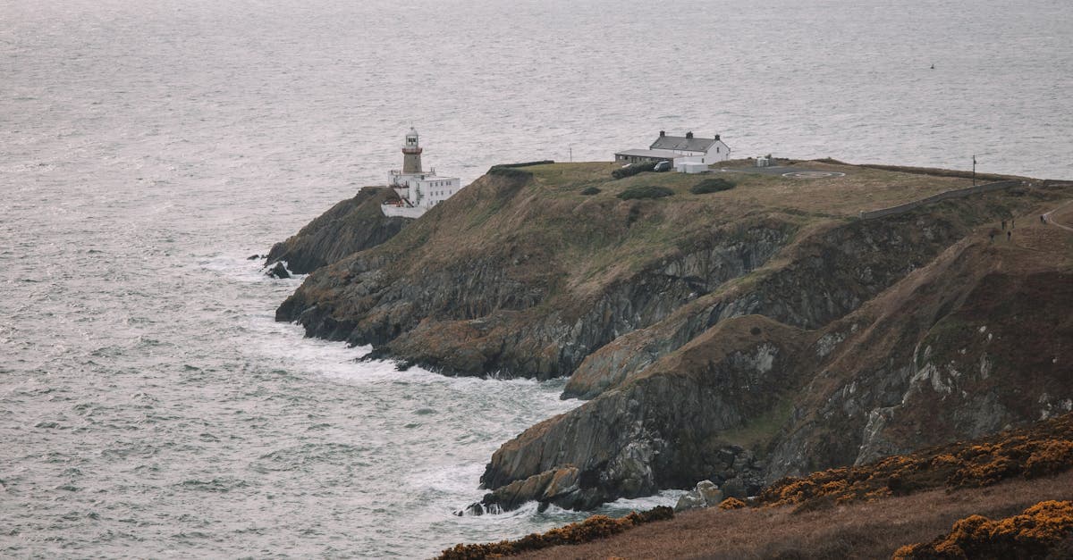 Baily Lighthouse on Howth Head cliffs overlooking the sea during Ireland's rainy season