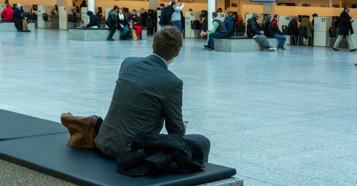 Businessman seated in an airport terminal reflecting long us visa appointment wait times at Canadian locations