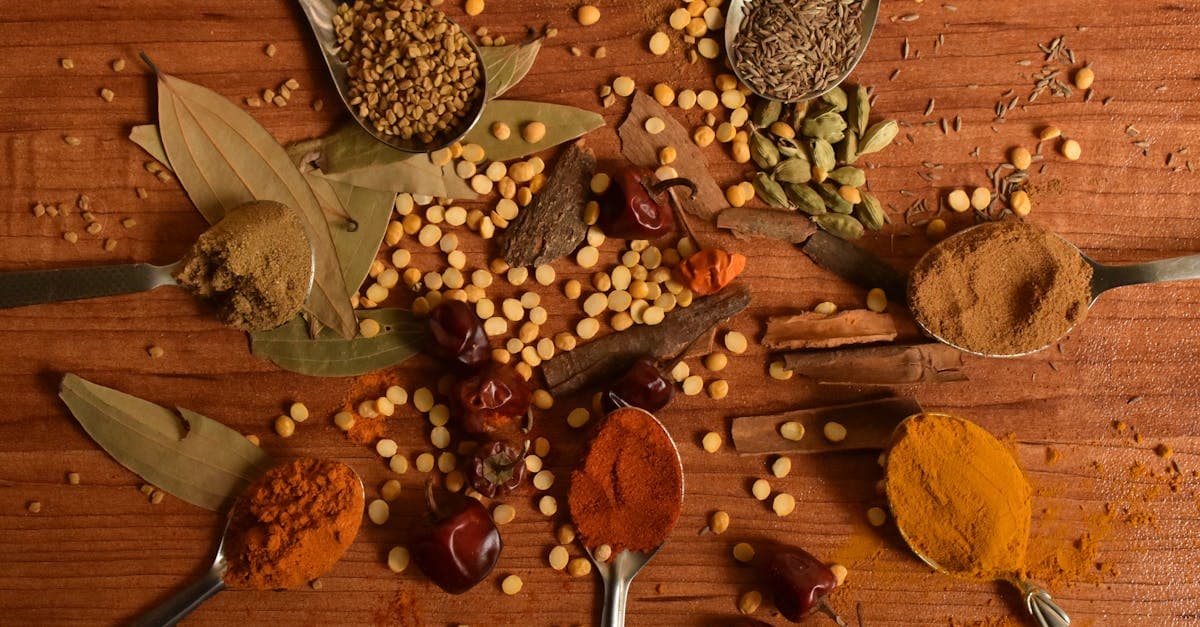Especias de gastronomía india dispuestas creativamente en mesa de madera para técnica culinaria del tadka