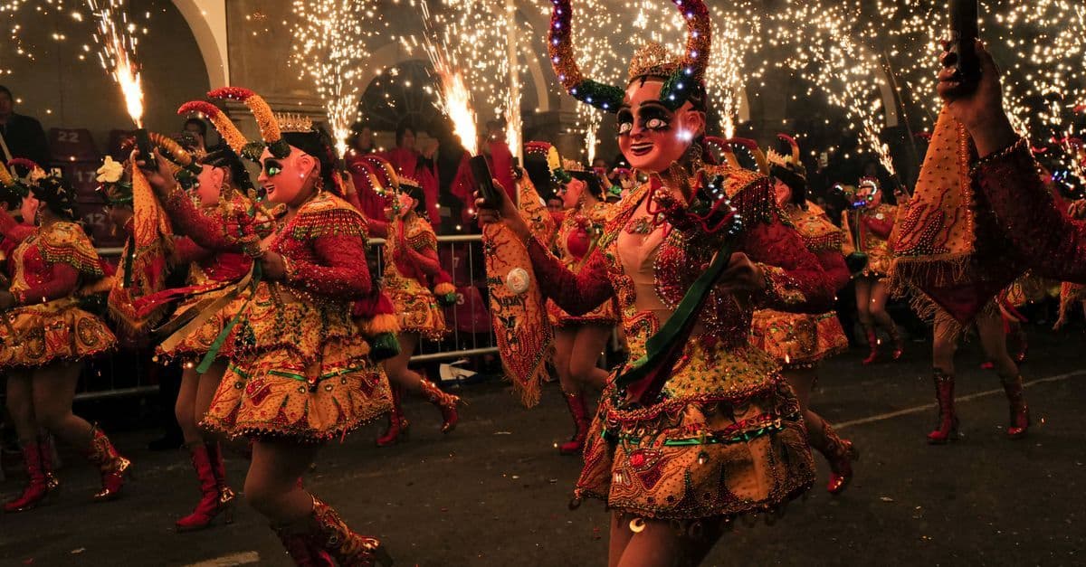 Danzantes con vistosos trajes iluminan la noche en un carnaval boliviano, evocando la energía de los Premios Lo Nuestro 2026.