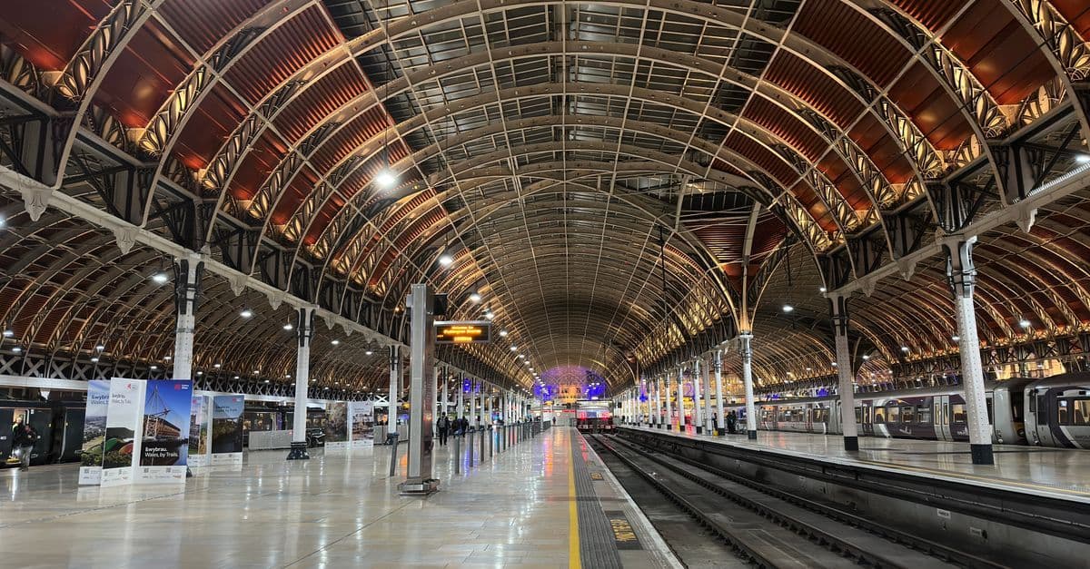 Paddington Station's vaulted Victorian interior at night, a major transport hub for reaching International Hall
