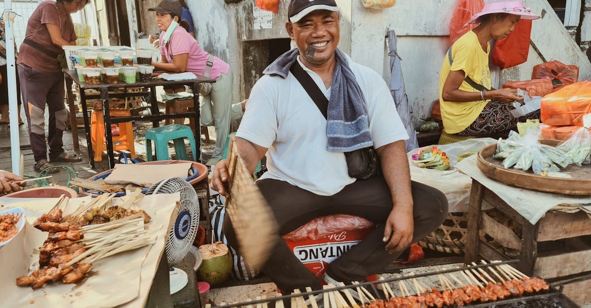 Local vendor grilling fresh satay at a bustling Bali street market, a standout foodie thing to do in Bali