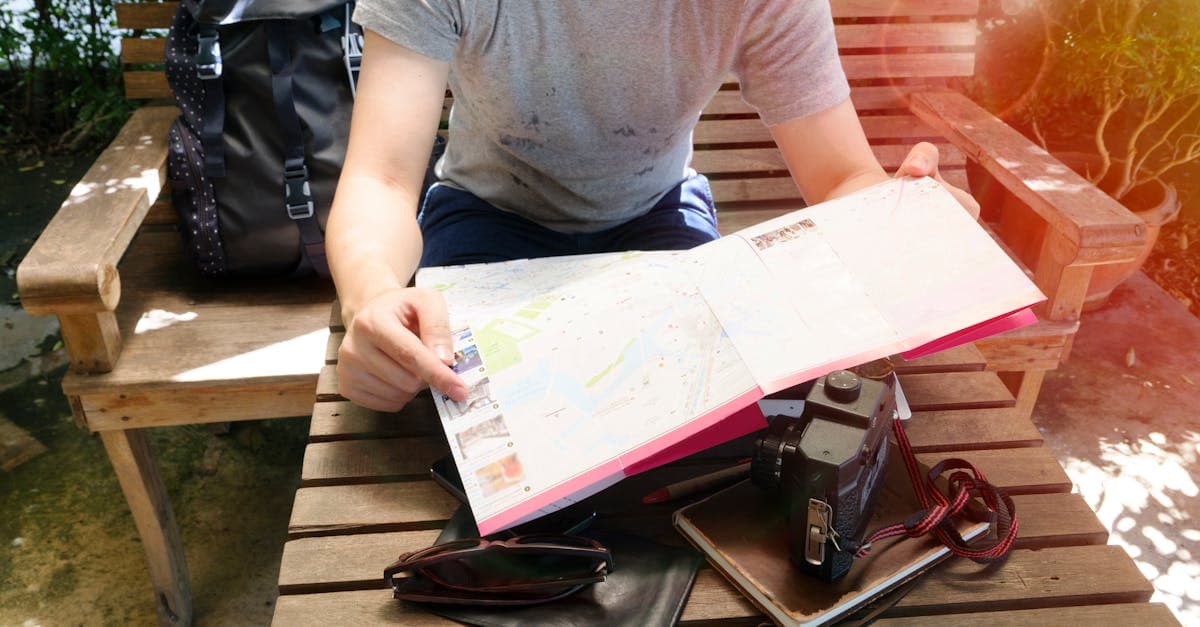 Young traveller with a map and backpack researching how to plan a trip to India.
