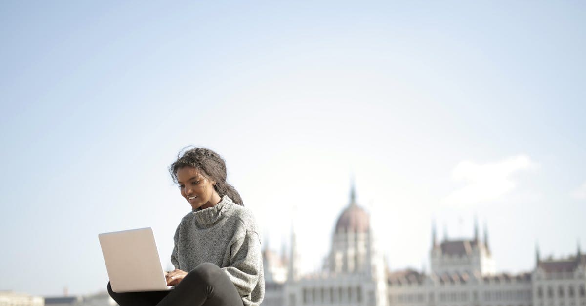 Kobieta pracuje na laptopie przed Parlamentem w Budapeszcie – ile kosztuje internet za granicą w 2026