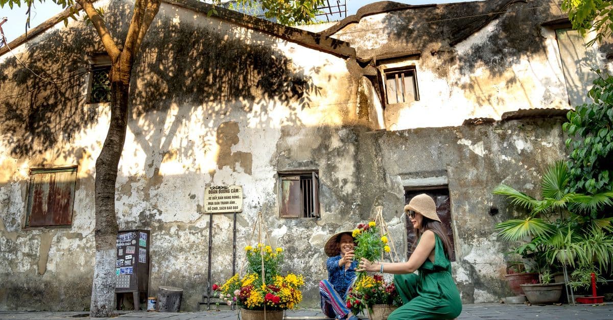 Young female traveller buying street flowers in Vietnam, avoiding common vietnam visa for australian application mistakes.