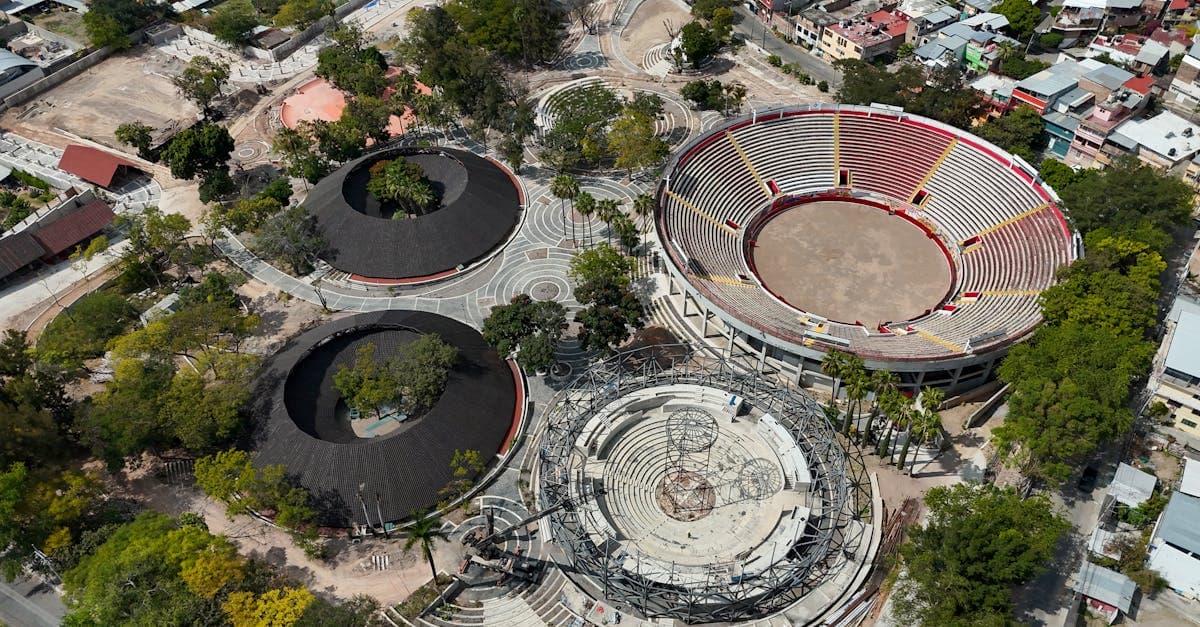 Vista aérea de complejo deportivo en Chilpancingo rodeado de árboles, escenario para grandes eventos y ceremonias