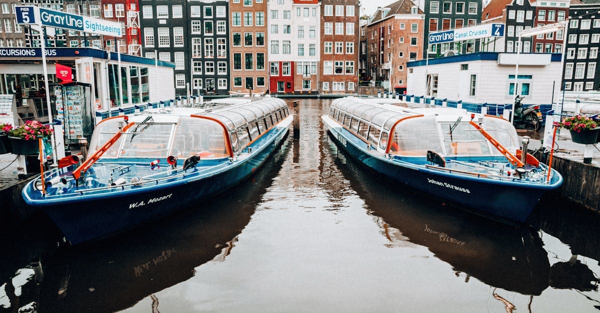 Colourful tour boats moored along Amsterdam's historic canals, highlighting classic things to do in amsterdam