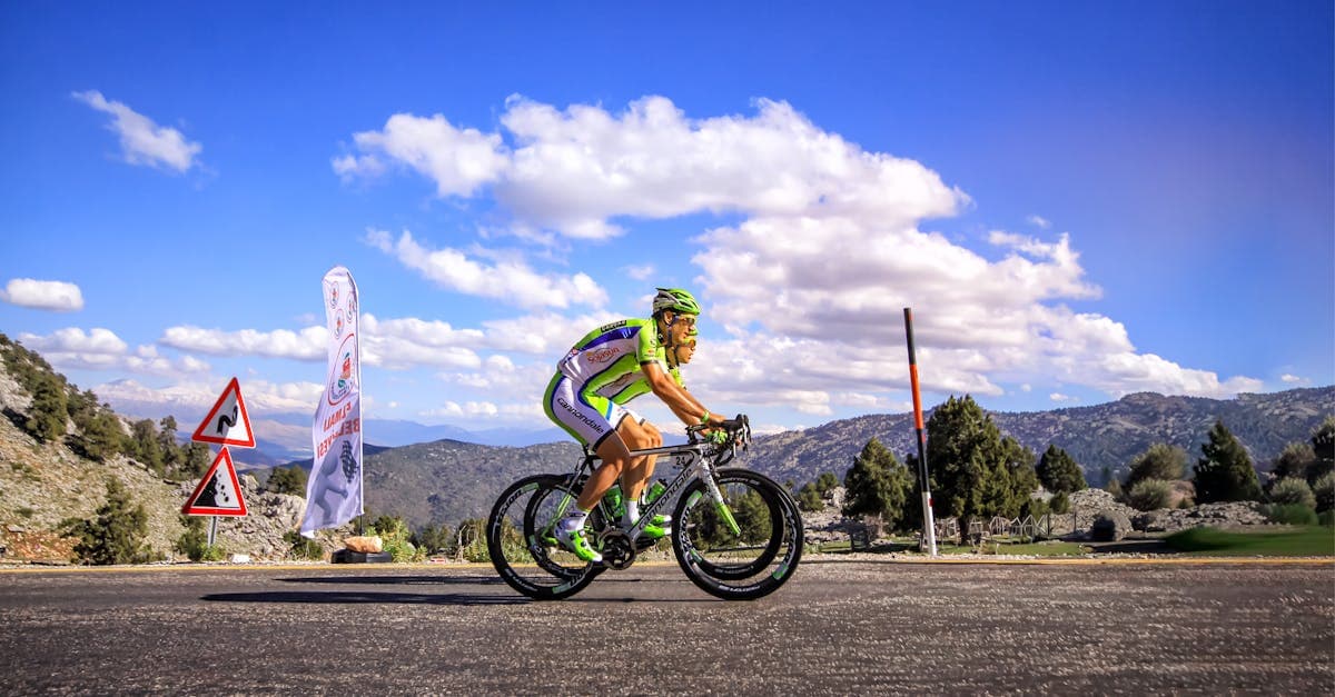Wielrenner klimt een schilderachtige bergweg omhoog tijdens alpe d'huzes 2026 met strak blauwe lucht