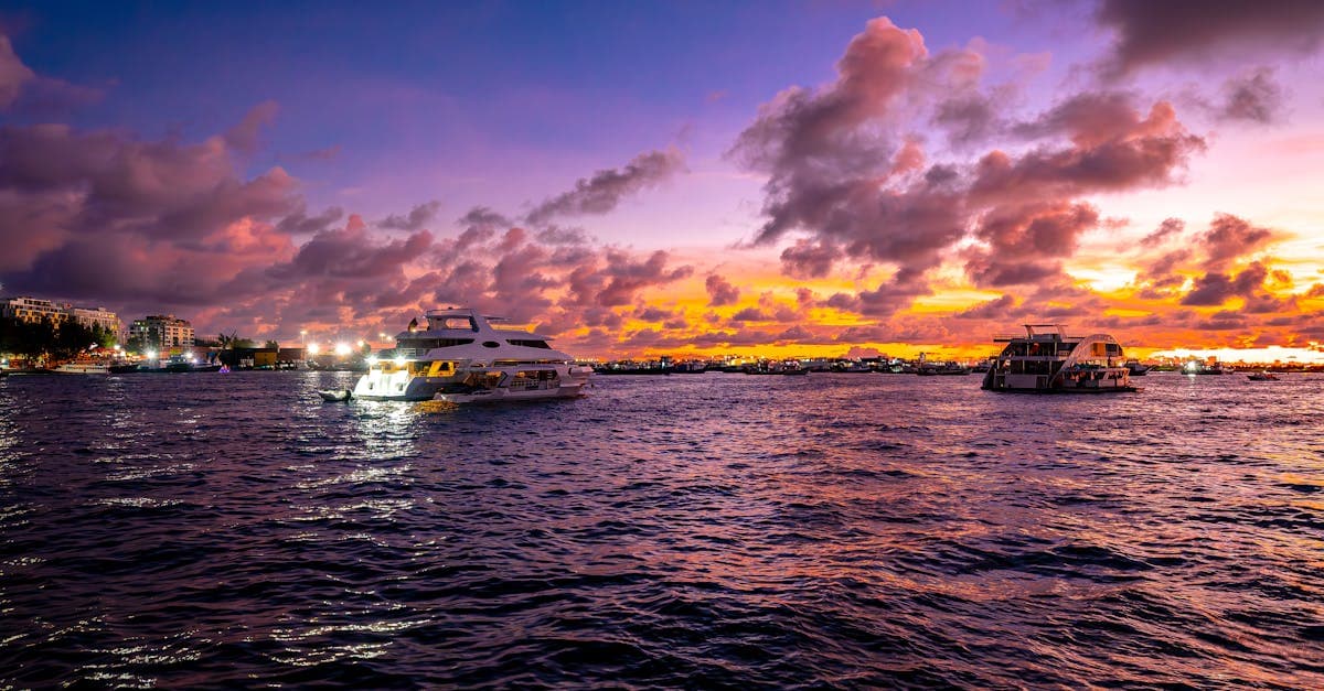 Luxury yachts moored at a glowing Maldives sunset during the cheapest off-peak months to visit