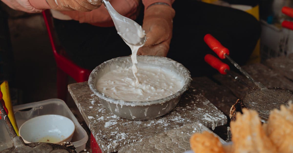 Vietnamese street vendor crafting traditional waffles with fresh batter in Bình Thuận market
