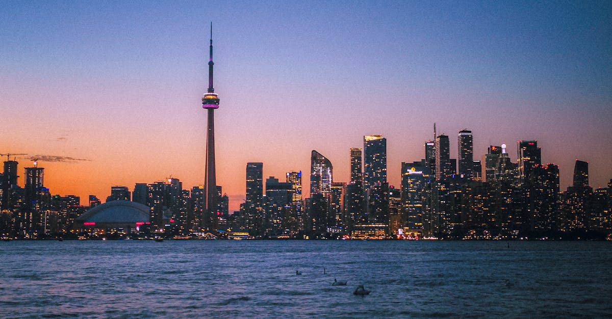 Toronto's modern skyline at twilight featuring the CN Tower and waterfront, departure point for Tokyo-bound flights![image